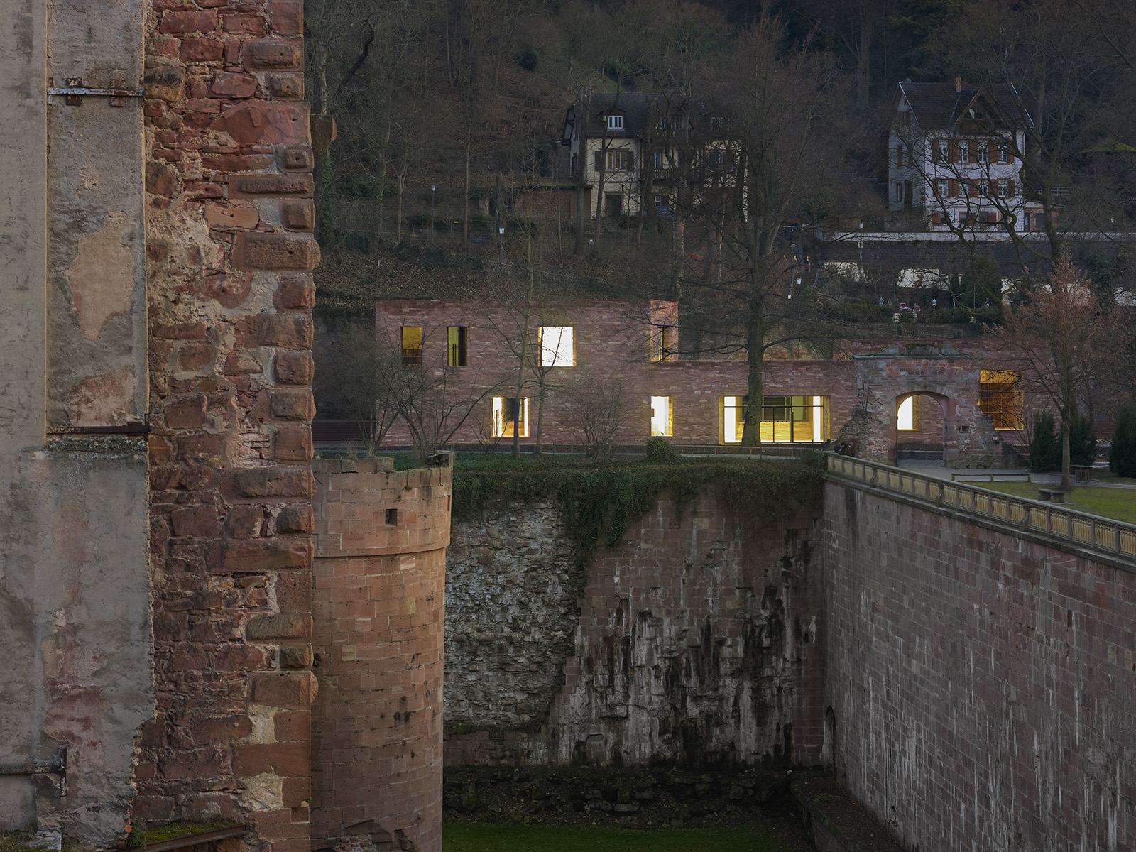 Blick vom Heidelberger Schloss zum Besucherzentrum bei Dämmerung